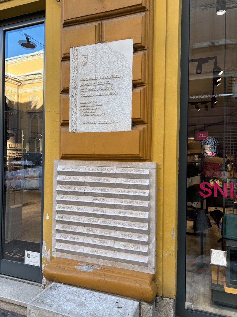 Меморіальна табличка з іменами загиблих біля троянди