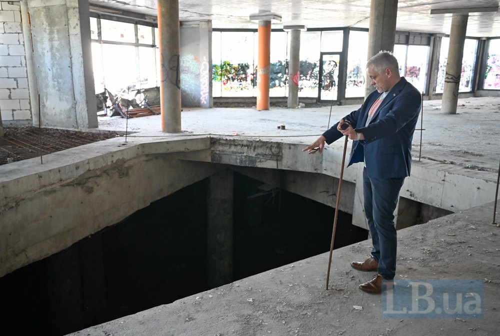Віталій Білецький показує недобудований вхід з площі в підземний ТРЦ.