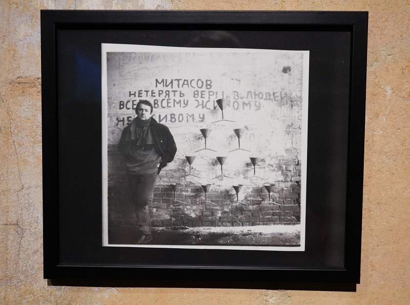 Павло Маков поруч із Фонтаном виснаження на міській стіні на тлі написів Олега Мітасова