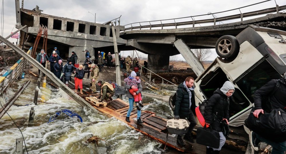 Евакуація під обстрілами: люди проходять через пошкоджений обстрілами російською армією міст в Ірпіні, 7 березня 2022 року