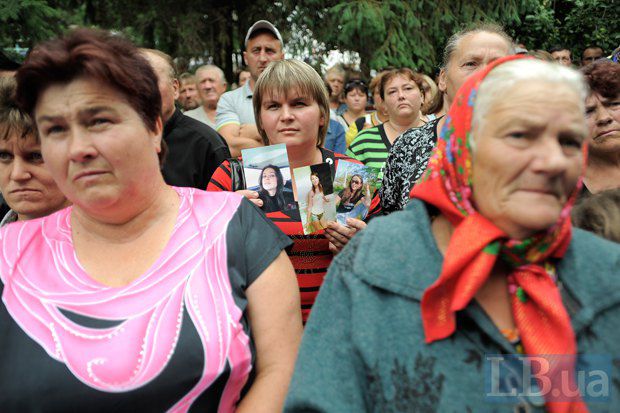 Жінка по центру фото тримає фото Ірини Крашкової