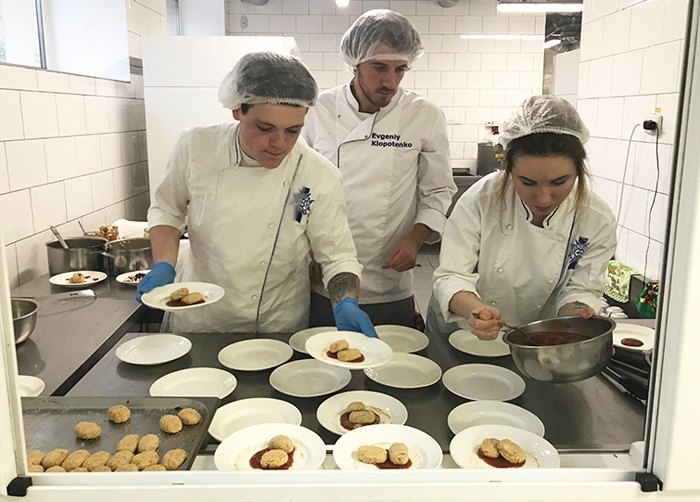 Кулінар Євген Клопотенко (у центрі) слідкує за приготуванням на кухні шкільної їдальні
