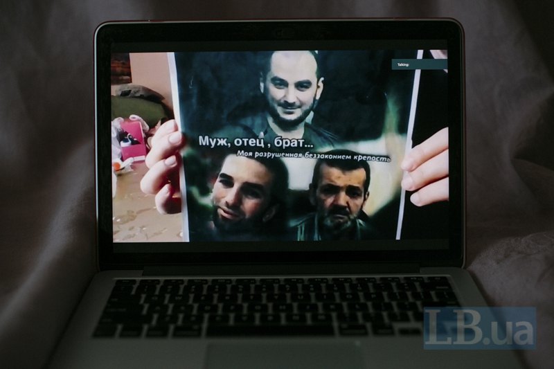 Фатма тримає в руках фото батька, брата та чоловіка.