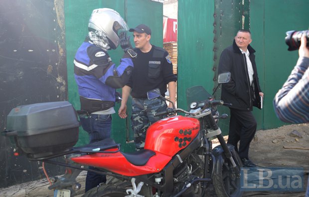 Активист Игорь Луценко(в мотоэкипировке) общается с охранником стройки