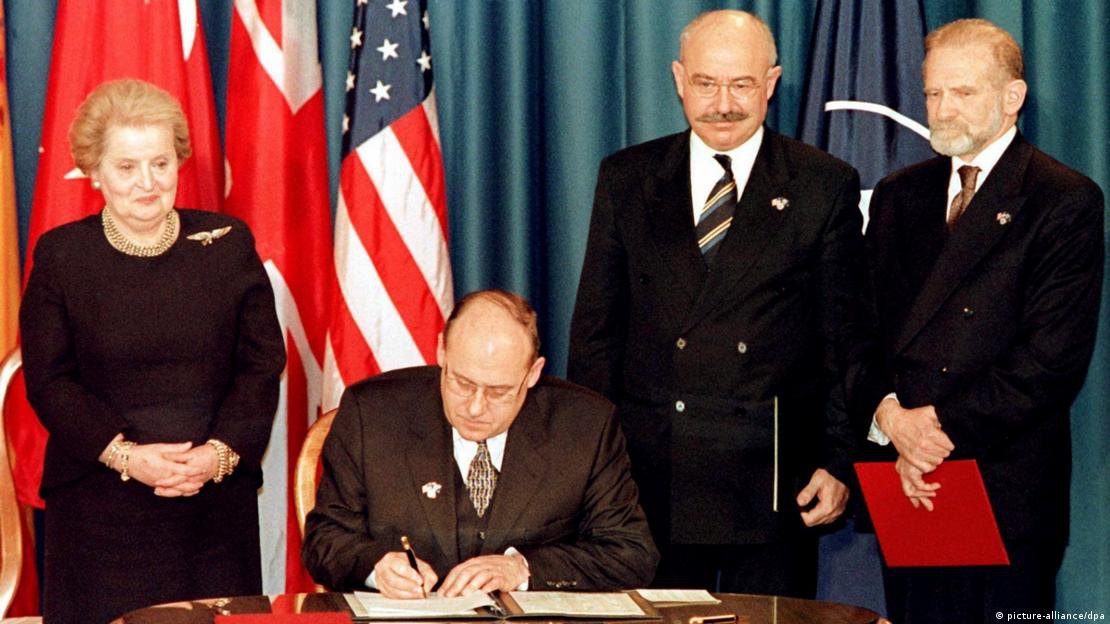 Глава МЗС Чехії підписує документ про вступ країни до НАТО. Зліва від нього – держсекретар США Олбрайт, праворуч – колеги з Угорщини та Польщі.
