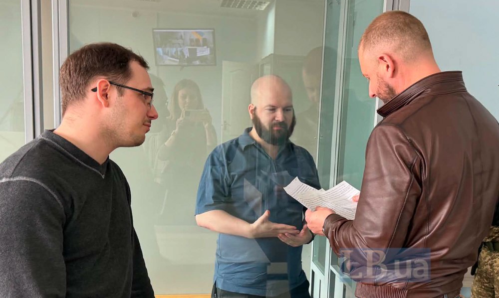 Адвокат підсудного Михайло Тарасенко (праворуч) спілкується з підсудним Роопе Мікаелем Мустоненом через перекладача ( ліворуч)