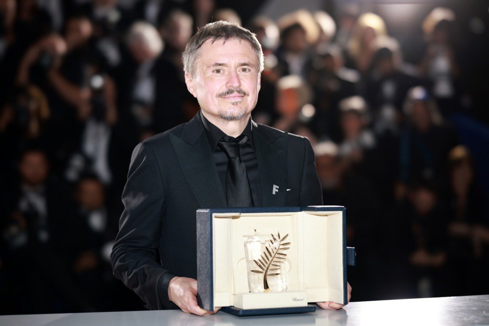 Режисер Крістіан Мунджіу позує з премією «Золота пальмова гілка» за фільм «Фйорд» під час фотоколу переможців у Каннах, 23 травня 2026 року.