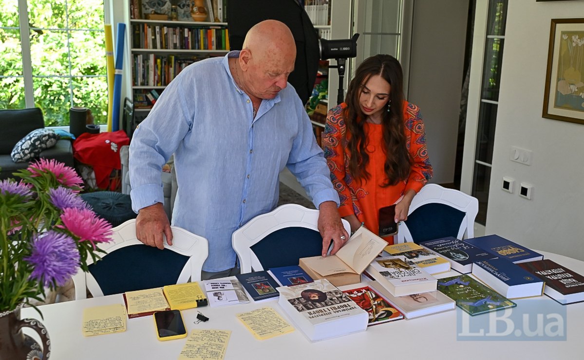 Микола Жулинський показує книгу «Із забуття – в безсмертя» журналістці LB.ua Анжеліці Сизоненко