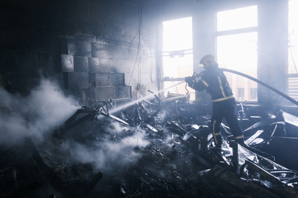 Рятувальники гасять пожежу на місці ракетного обстрілу промислової будівлі в Харкові, 20 березня 2024 р.