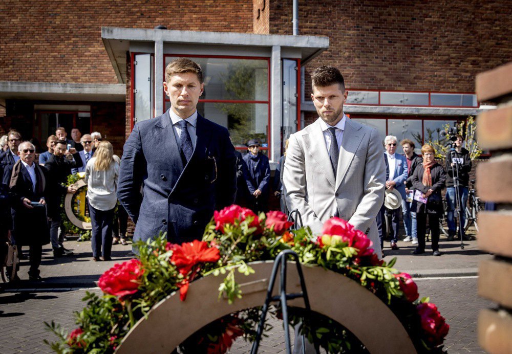 Колишні футболісти Євген Левченко (ліворуч) і Клаас Ян Гунтелаар покладають вінок під час національного спортивного вшанування в Нідерландах до статуї Прометея перед Олімпійським стадіоном в Амстердамі, 4 травня 2022 року.