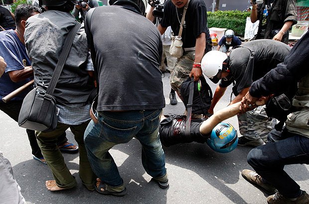 Застрелянного итальянского фотографа уносят с места столкновений. Бангкок, 2010