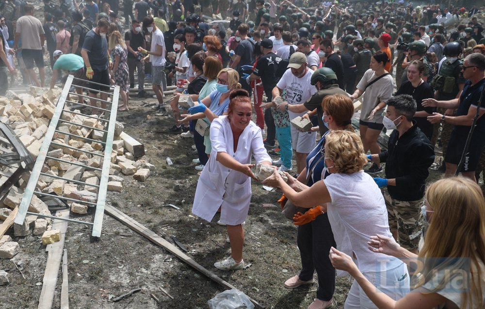 People help to clear the rubble