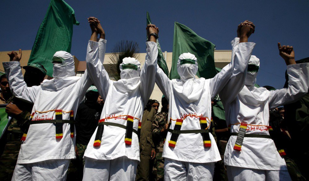 Hamas militants dressed as suicide bombers take part in a march in the Al-Nusairat refugee camp in the central Gaza Strip, 19 March 2010