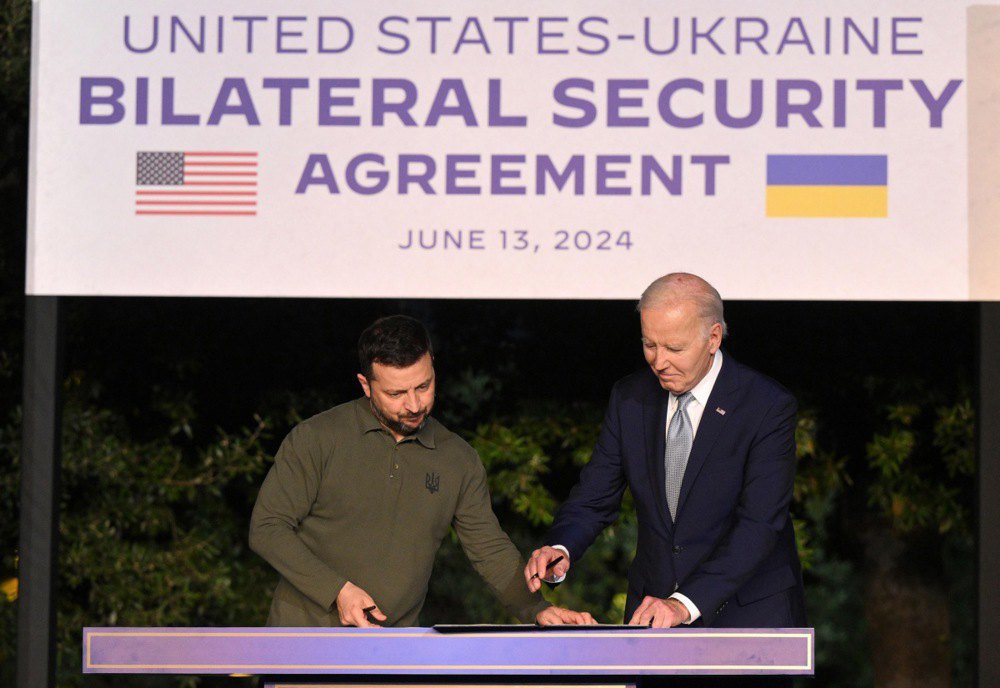 US President Joe Biden and Ukrainian President Volodymyr Zelenskyy sign a security agreement after a bilateral meeting on the sidelines of the G7 summit in Italy, 13 June, 2024.