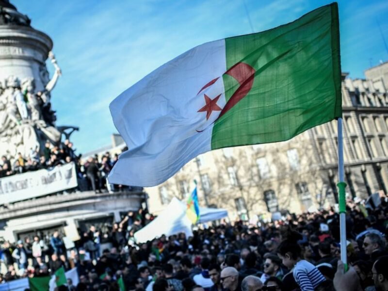 The flag of Algeria flies on the Place de la République in Paris