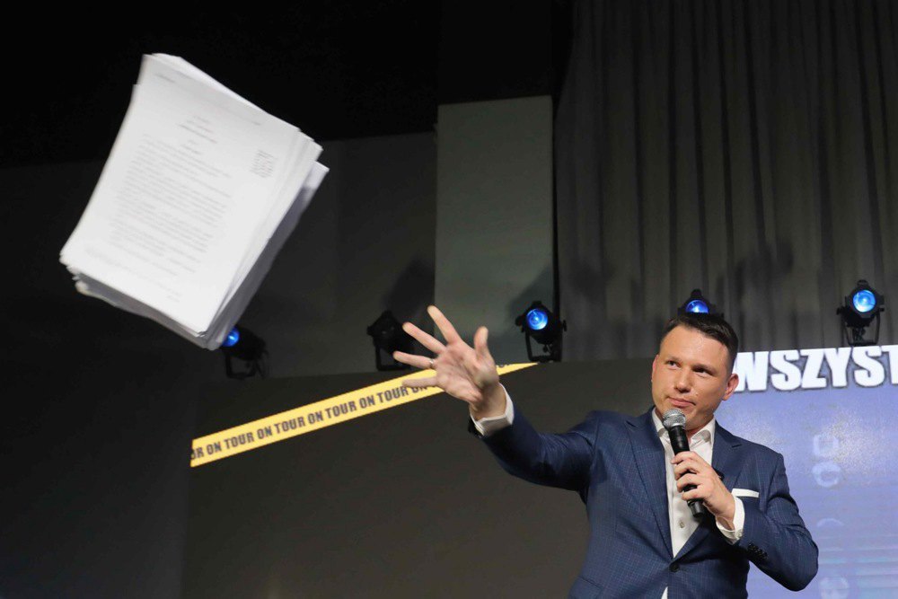 Sławomir Mentzen throws papers during a speech at a meeting of the Confederation with locals in Warsaw