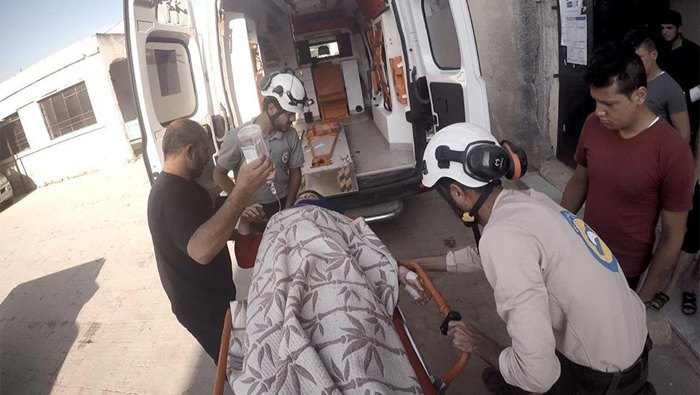 White Helms volunteers evacuate the wounded after the shelling, Idlib province, Syria