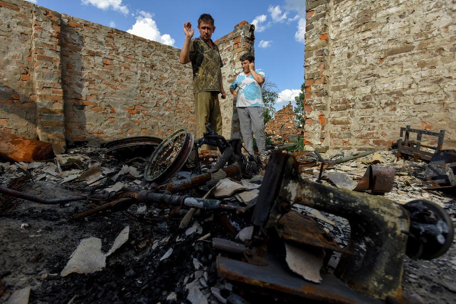 Residents standing on the ruins of their home in the Kyiv Region, 2022.
