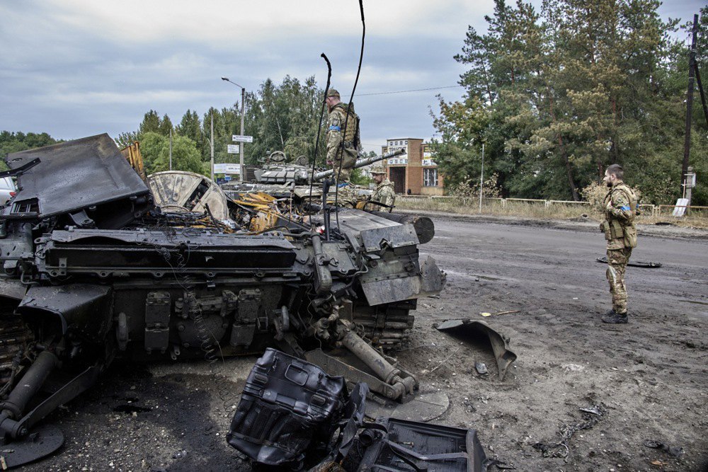 Ukrainian soldiers inspect a destroyed tank in the city of Izyum, Kharkiv Region, after its liberation from Russian forces, September 2022