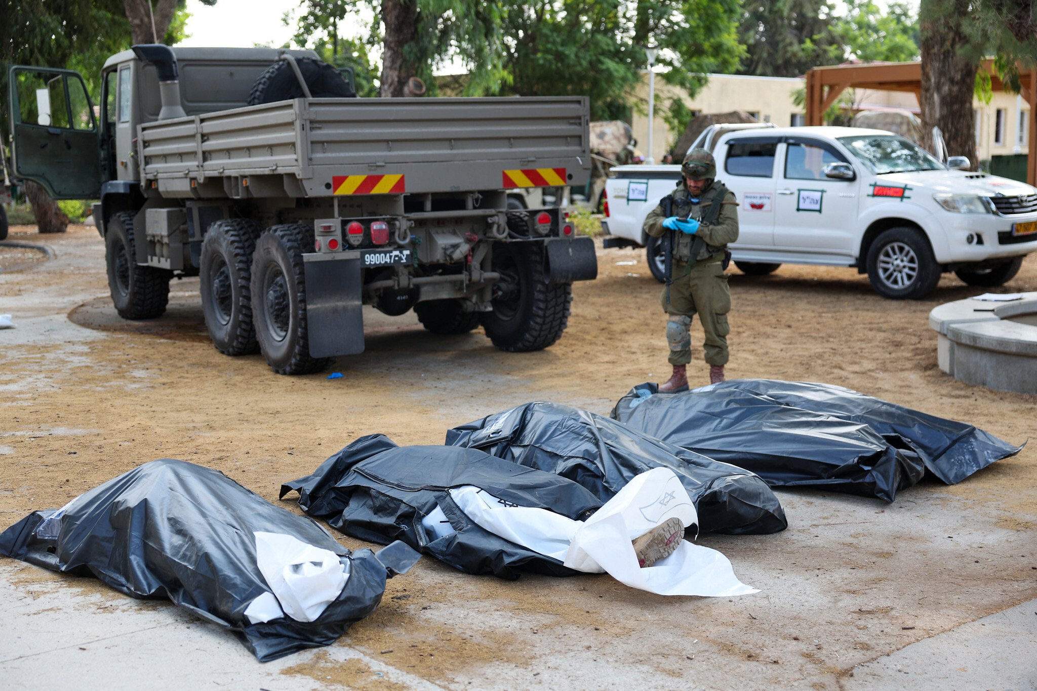 IDF soldiers remove the bodies of Israelis killed during an attack by Palestinian terrorists on 7 October 2023, in Kibbutz Kfar Aza.