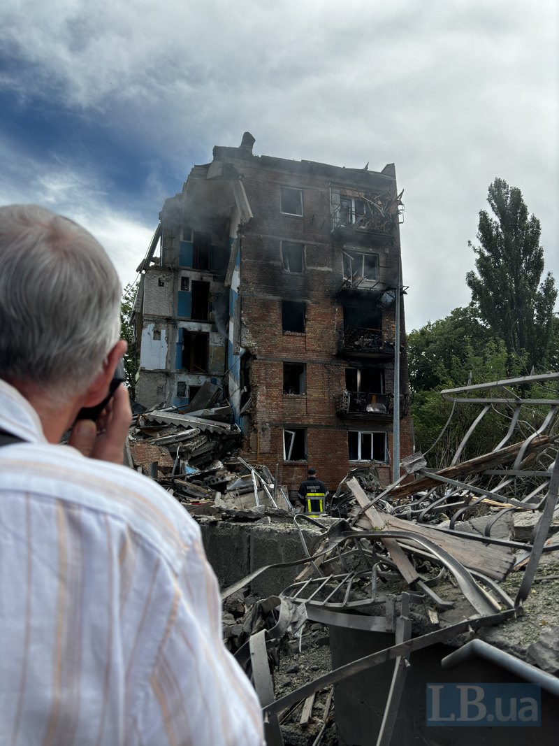 Rescuers work at the site of a hit to a residential building in the Shevchenkivskyy district.