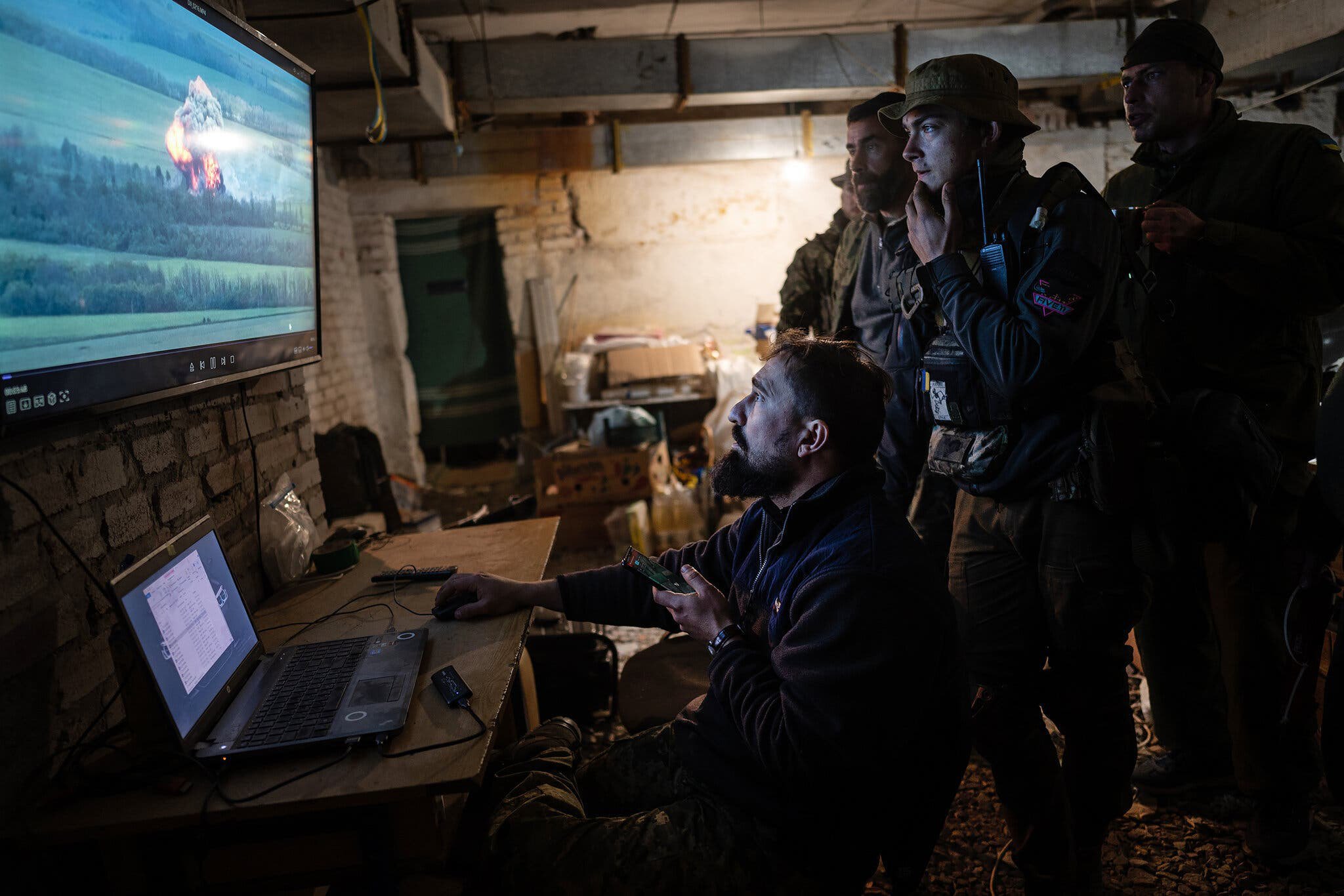 The military is watching the battle on the screen.