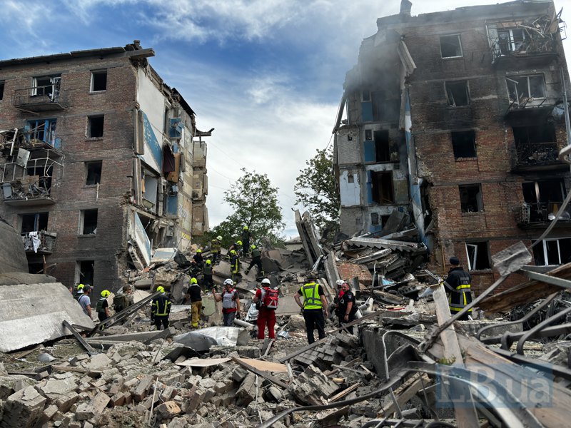 Rescuers work at the site of a hit to a residential building in the Shevchenkivskyy district.