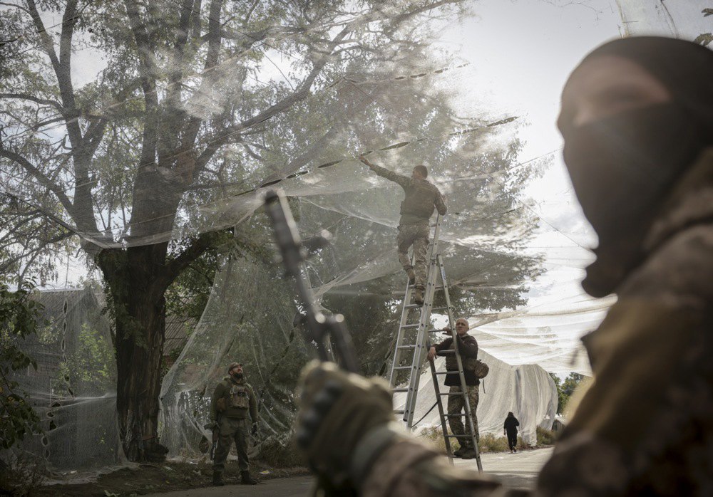  Servicemen of the 24th Mechanised Brigade named after King Danylo install nets along roads to protect against drone attacks in one of the frontline towns of Donetsk Region, 19 September 2025.