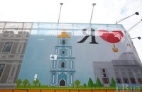 Сгоревшее здание бывшего гастронома на Крещатике закрыли новым баннером