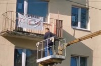 В Минске коммунальщики сняли с балкона ткань с надписью "Это не флаг"