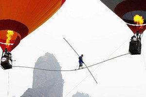 Китайский акробат прошел по канату между двух воздушных шаров
