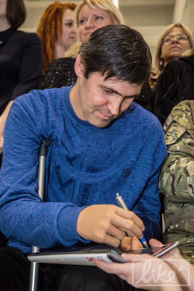 Слава Буйновский дает автограф протезированной рукой