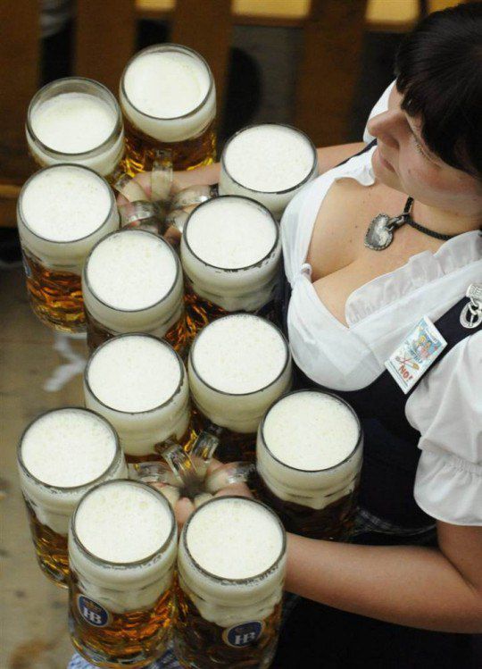 Бармен несет двенадцать бокалов пива гостям 178-го фестиваля «Октоберфест»